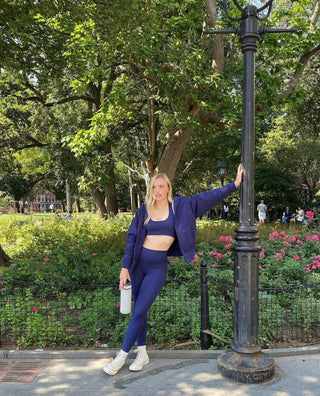 a woman standing next to a street light