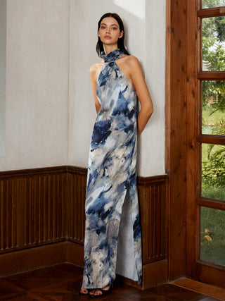 a woman in a blue and white dress standing against a wall