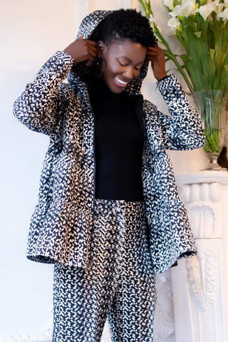 a woman wearing a black and white patterned suit