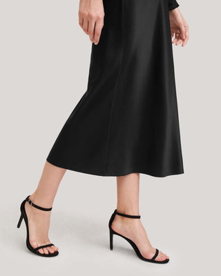 a woman wearing a black skirt and heels