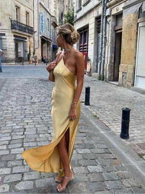 a woman in a yellow dress walking down the street