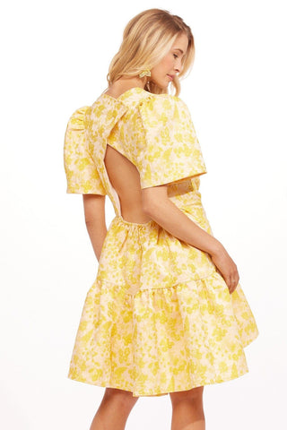 a woman wearing a yellow floral print dress