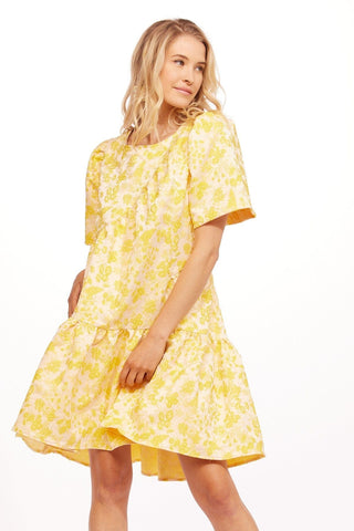 a young girl in a yellow floral dress