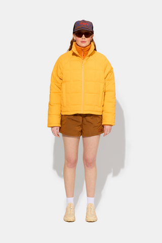 a woman in a yellow jacket and brown shorts