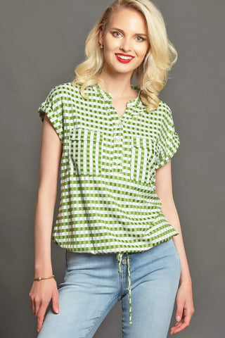 a woman wearing a green and white checkered top