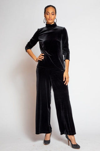 a woman wearing a black velvet jumpsuit