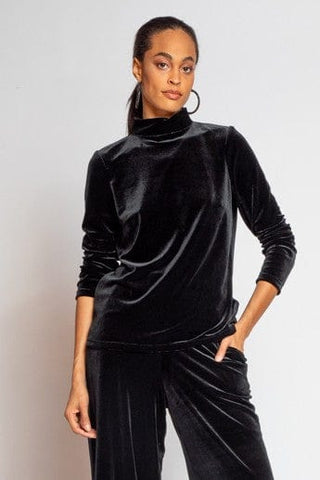 a woman wearing a black velvet jumpsuit