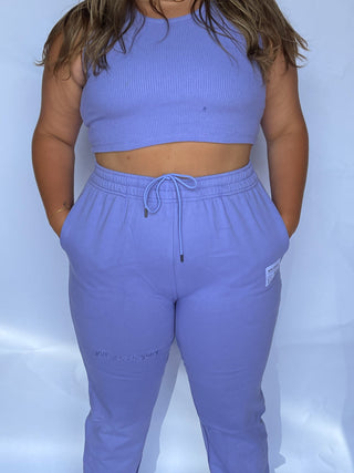 a woman in a blue crop top and sweat pants