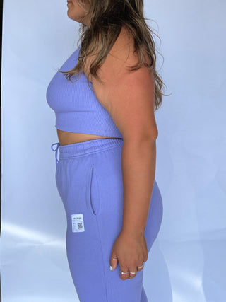 a woman in a blue crop top and sweat pants