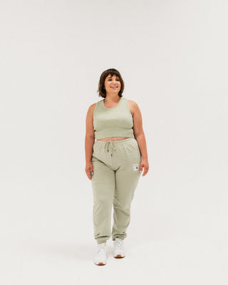 a woman in a green crop top and sweat pants