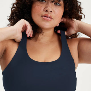 a woman with curly hair wearing a black tank top