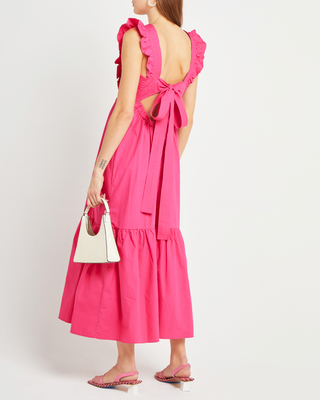 a woman in a pink dress with a white purse