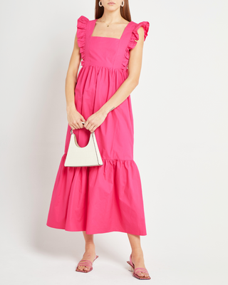 a woman in a pink dress with a white purse