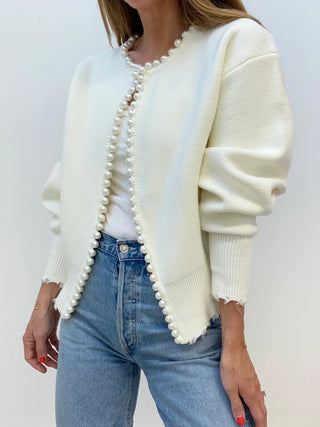 a woman wearing a white sweater and jeans