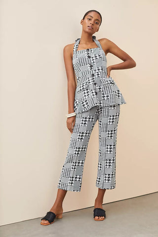 a woman wearing a black and white checked jumpsuit