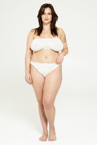 a woman in a white bikini top and panties