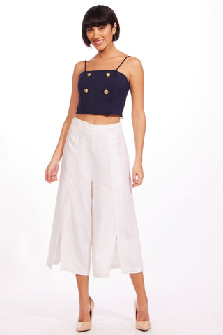 a woman wearing a cropped crop top and a white skirt