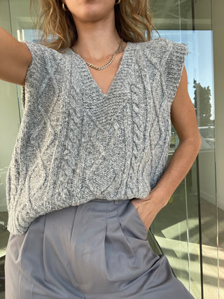 a woman wearing a grey cable knit top