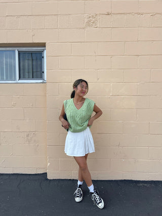 a woman standing in front of a brick wall