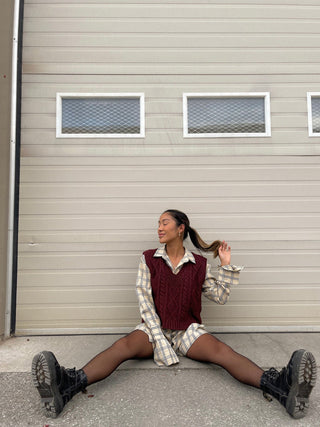 a woman sitting on the ground in front of a garage door