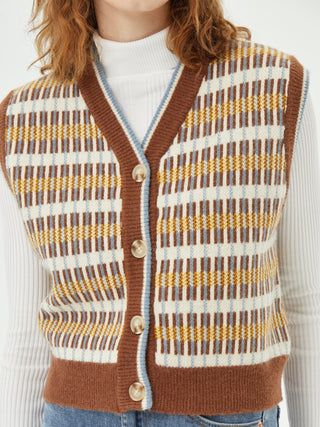 a woman wearing a brown and white sweater vest