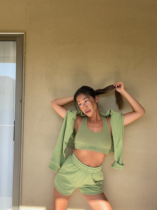 a woman leaning against a wall with her hair in the wind