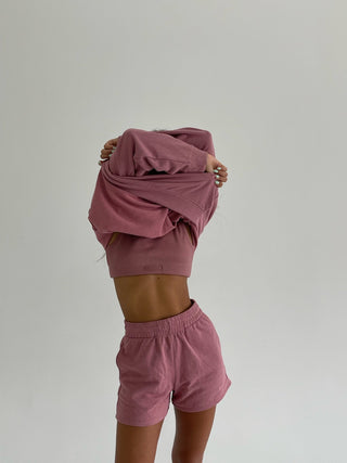 a woman in pink shorts and a hoodie