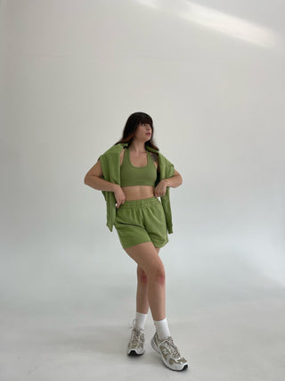 a woman in a green top and shorts