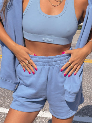 a woman wearing a blue crop top and shorts