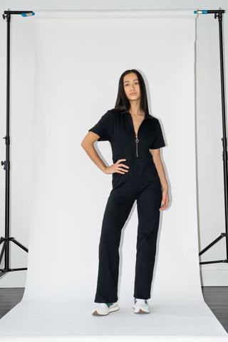 a woman standing in front of a white backdrop