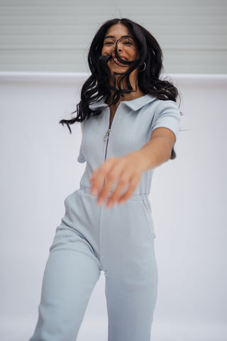 a woman in a blue jumpsuit is dancing