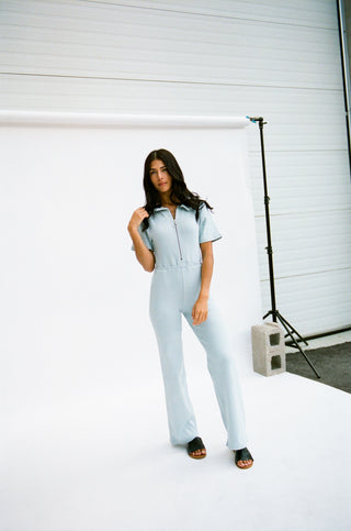 a woman standing in front of a white backdrop