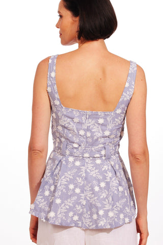 the back of a woman wearing a purple floral top