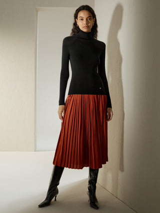 a woman wearing a black turtle neck sweater and a red pleaed skirt