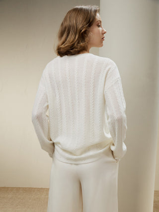 a woman wearing a white sweater and pants