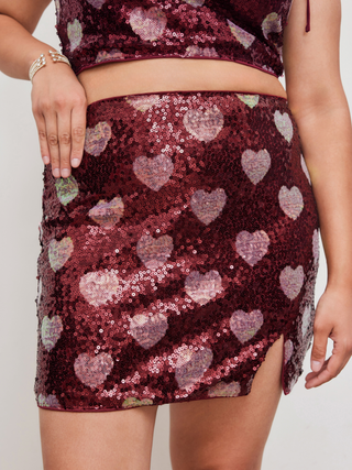 a woman is wearing a red skirt with hearts on it