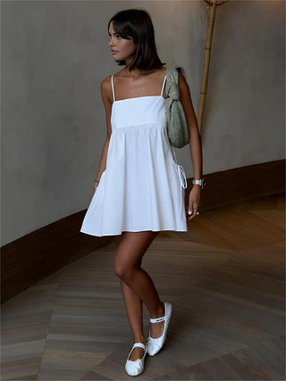 a woman wearing a white dress and white shoes