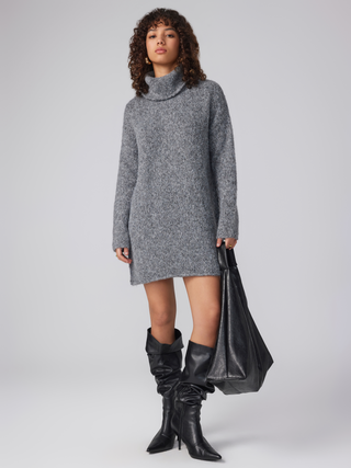 a woman in a grey sweater dress and black boots