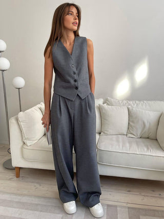 a woman wearing a grey jumpsuit and white sneakers