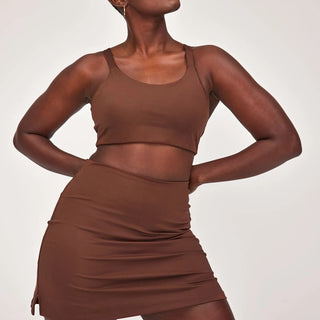 a woman in a brown top and skirt