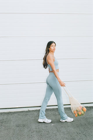 a woman in a blue jumpsuit holding a tennis racket