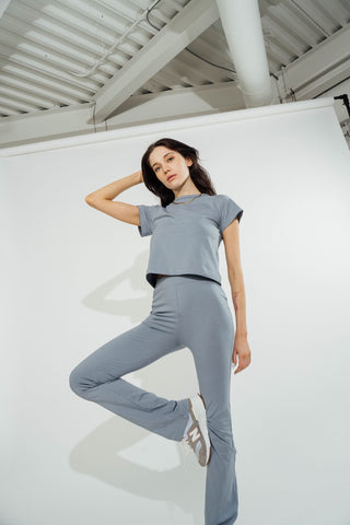 a woman in a grey top and grey pants