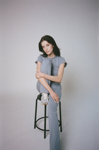 a woman sitting on top of a stool