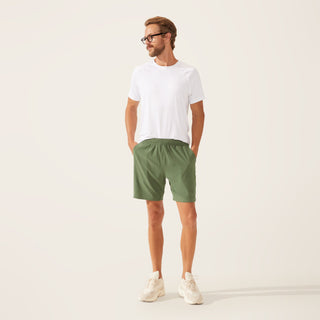 a man wearing a white t - shirt and green shorts