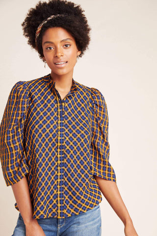 a woman wearing a yellow and blue checked shirt