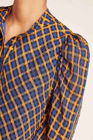 a woman wearing a blue and yellow checked shirt