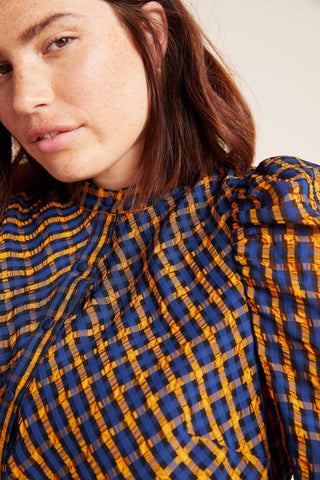 a woman wearing a blue and yellow plaid shirt