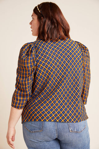 a woman wearing a blue and yellow plaid shirt