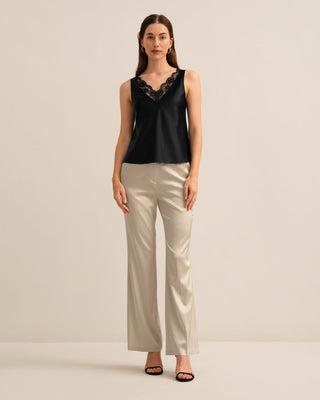 a woman in a black top and beige pants