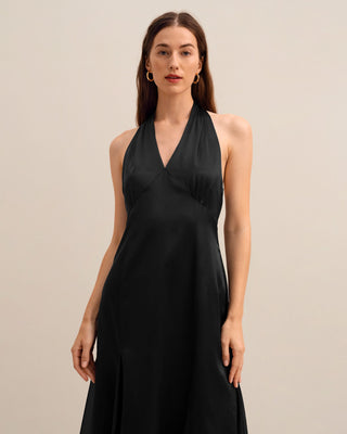 a woman wearing a black halt neck dress